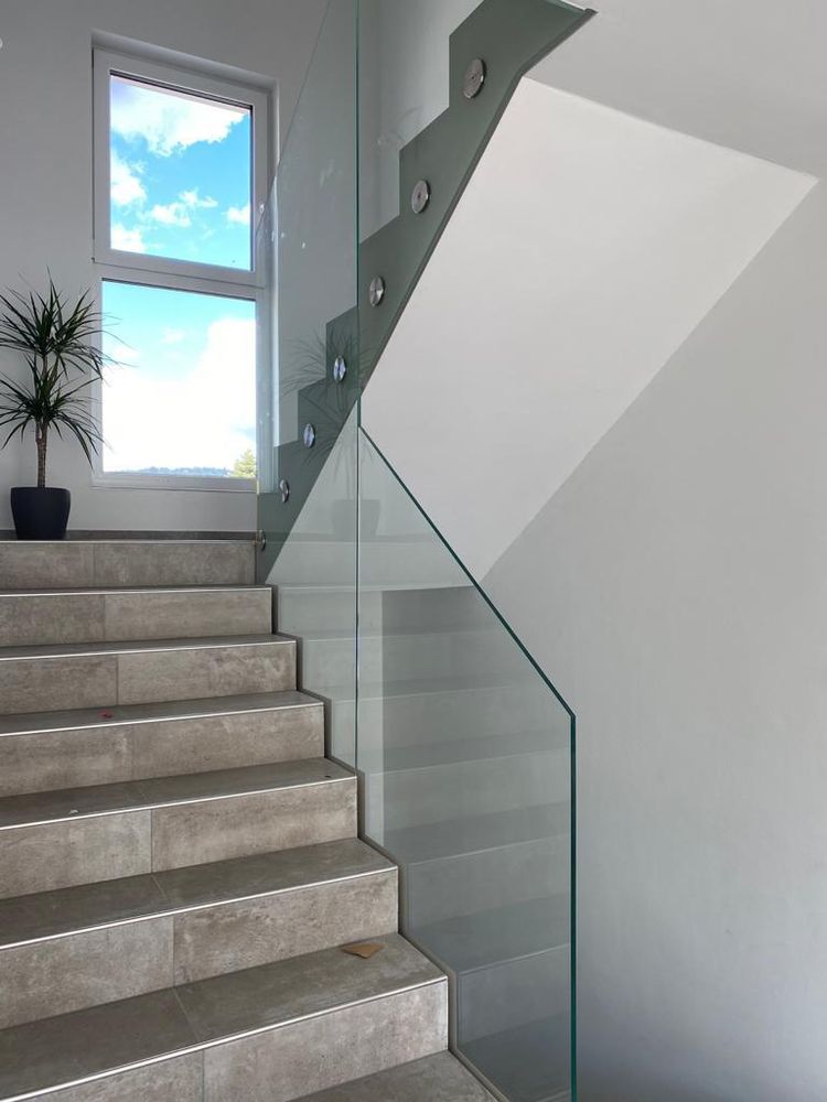 Betontreppe mit geschlossener Glasbrüstung als Absturzsicherung