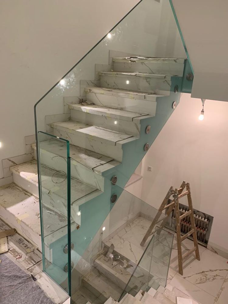 Geländer aus Verbundsicherheitsglas an einer Marmortreppe während der Bauphase