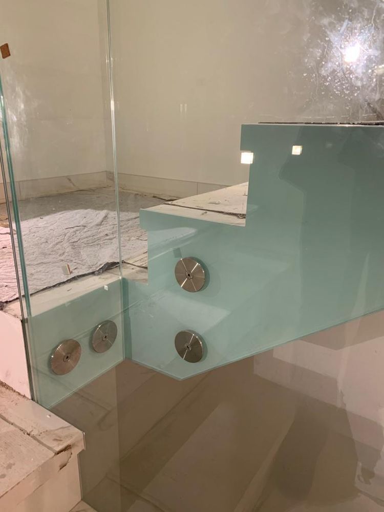 Detail eines Geländers aus grünem Verbundsicherheitsglas mit Punkthaltern aus Edelstahl