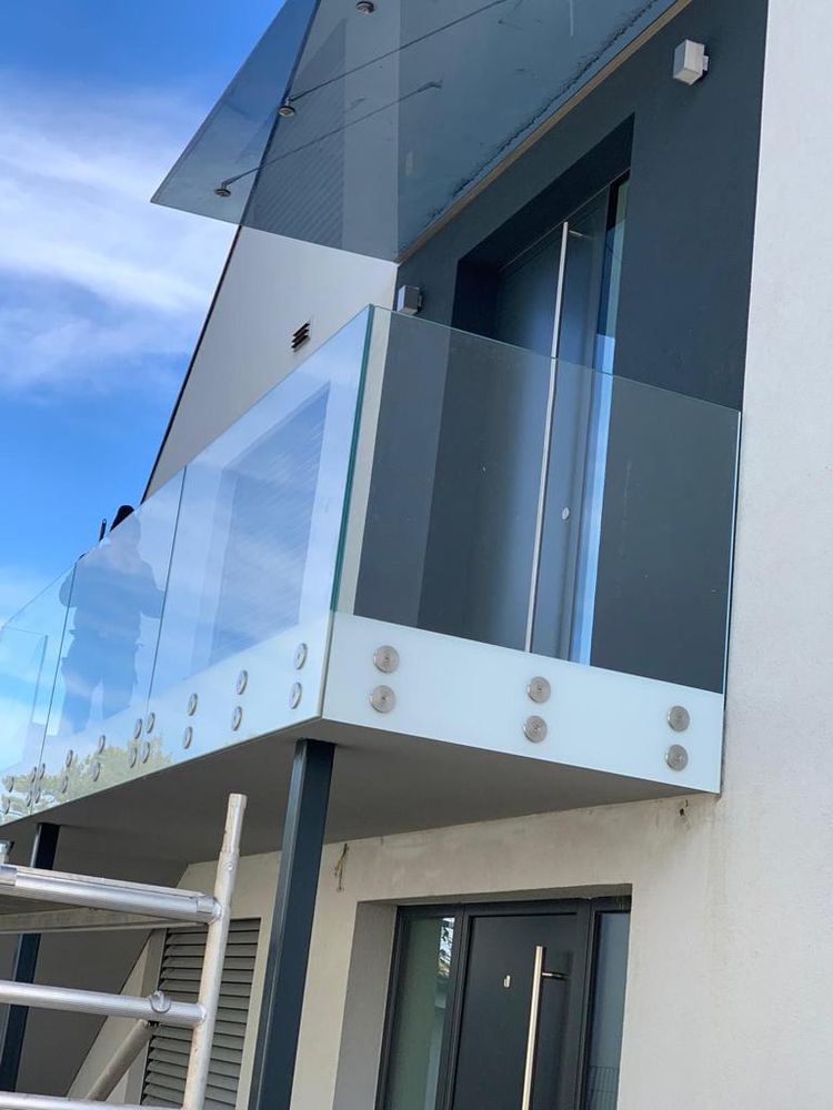 Balkonverglasung aus Glas mit Punkthaltern an einem modernen Wohnhaus