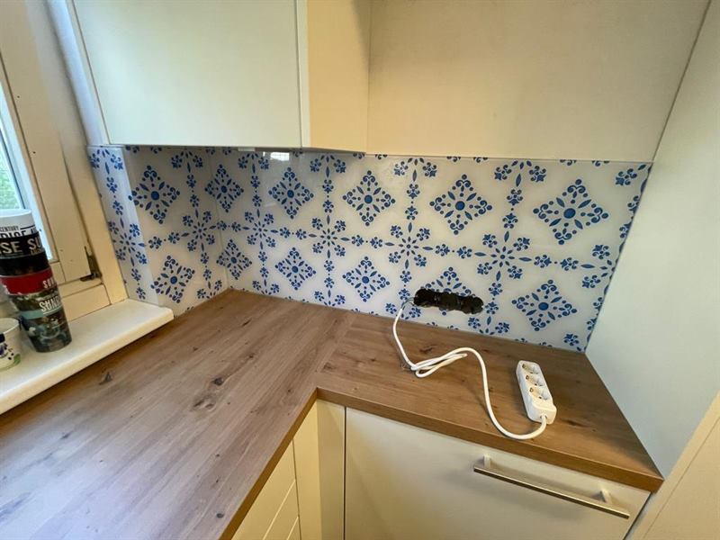 Küchenrückwand aus Glas, fugenlos zwischen Arbeitsplatte und Oberschrank montiert