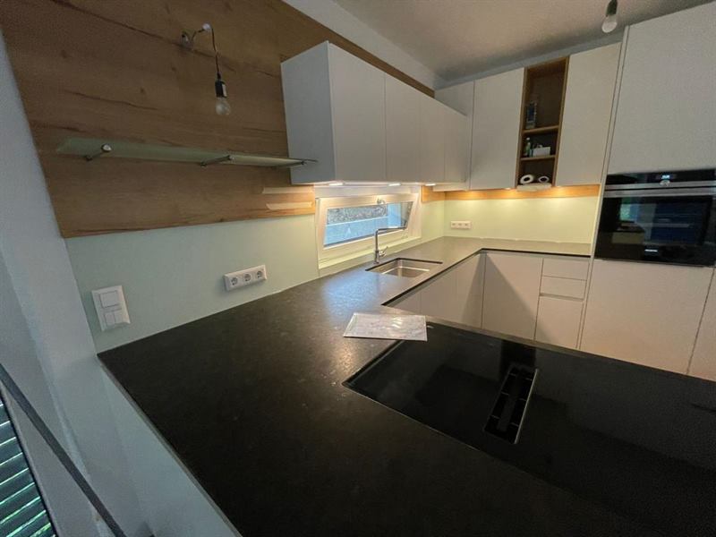 Küchenrückwand aus Glas, fugenlos zwischen Arbeitsplatte und Oberschrank montiert