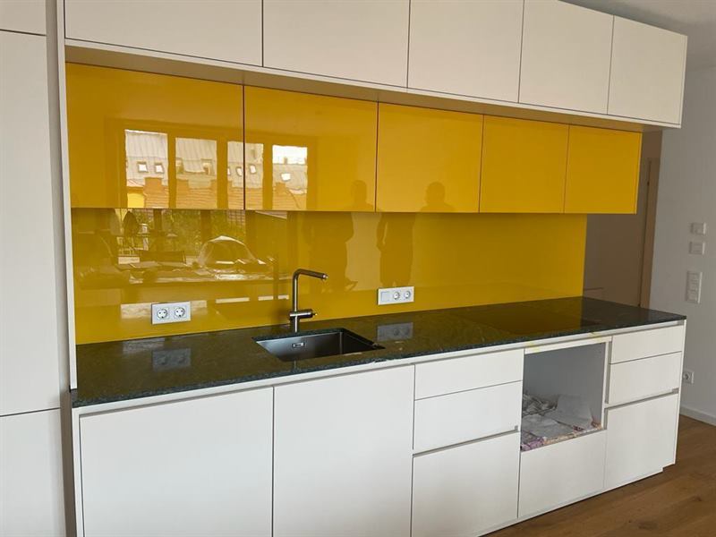 Küchenrückwand aus Glas, fugenlos zwischen Arbeitsplatte und Oberschrank montiert
