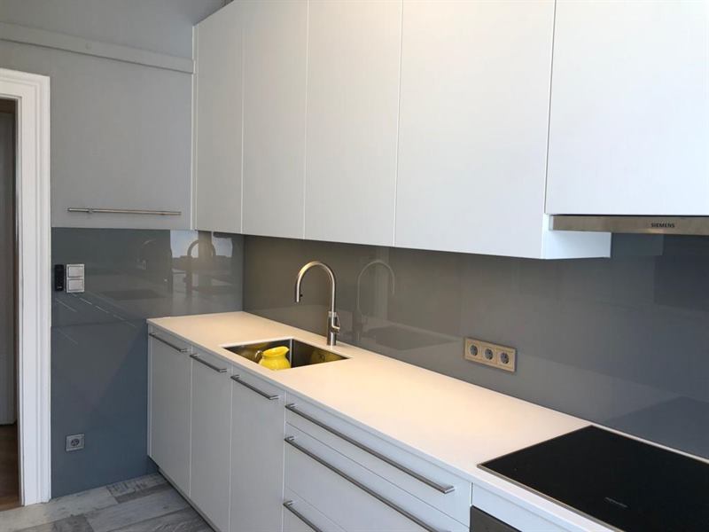 Küchenrückwand aus Glas, fugenlos zwischen Arbeitsplatte und Oberschrank montiert