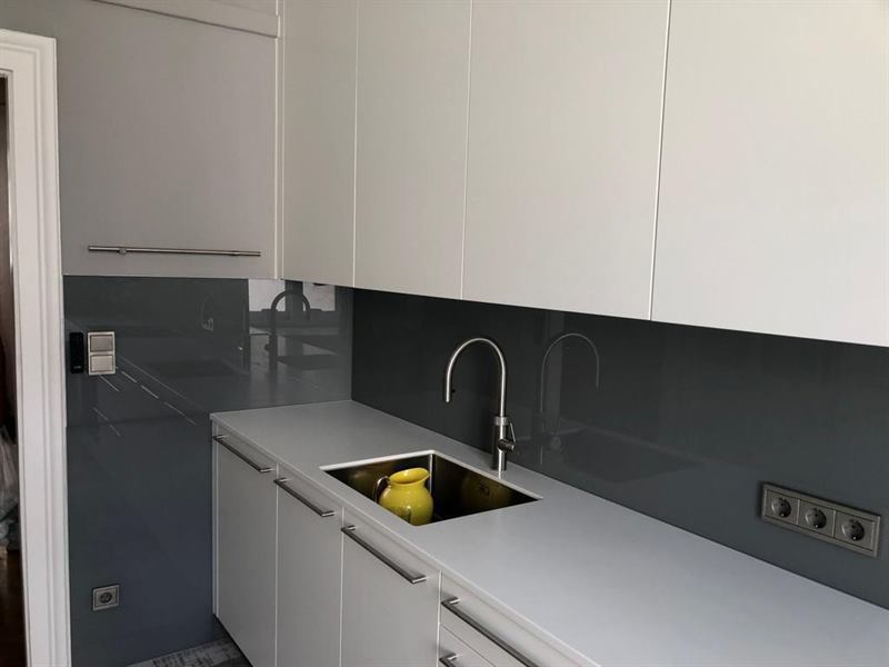 Küchenrückwand aus Glas, fugenlos zwischen Arbeitsplatte und Oberschrank montiert