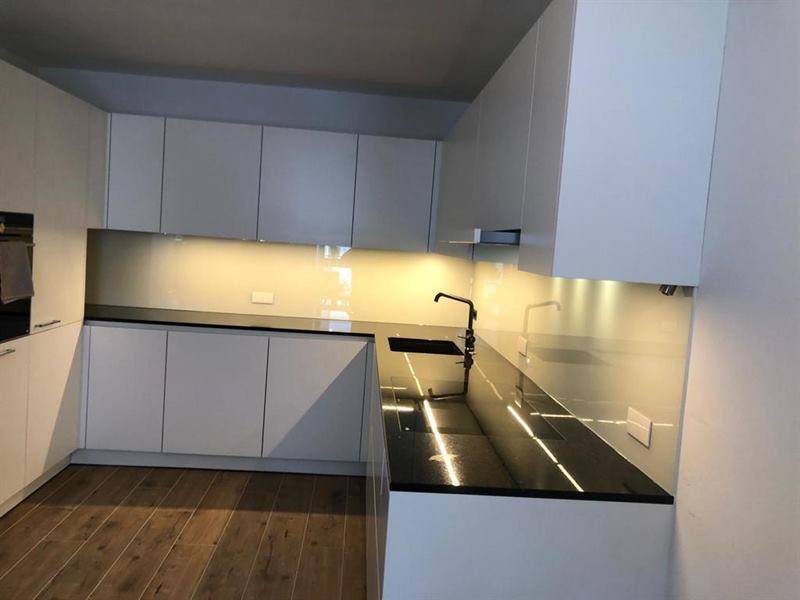 Küchenrückwand aus Glas, fugenlos zwischen Arbeitsplatte und Oberschrank montiert