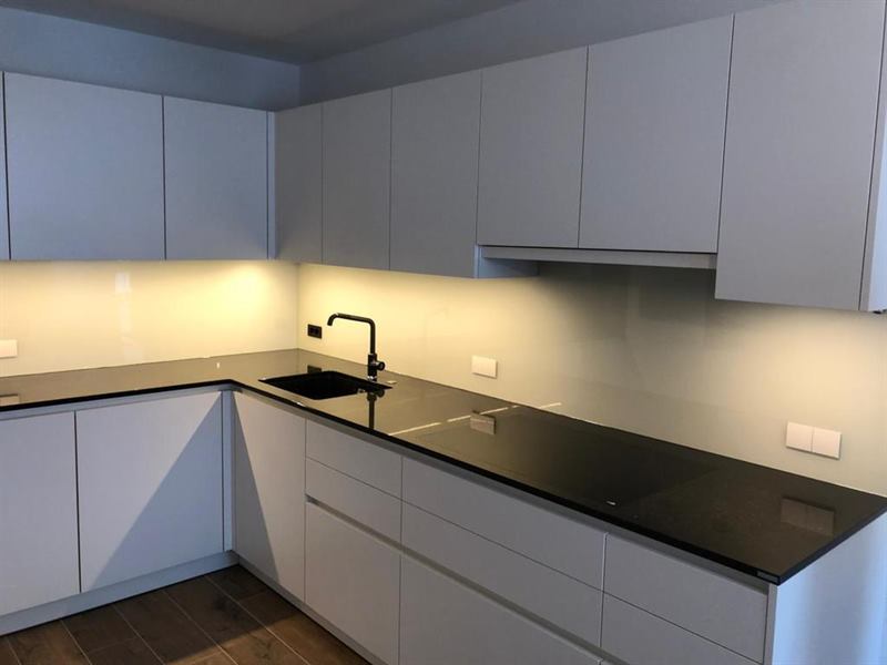 Küchenrückwand aus Glas, fugenlos zwischen Arbeitsplatte und Oberschrank montiert