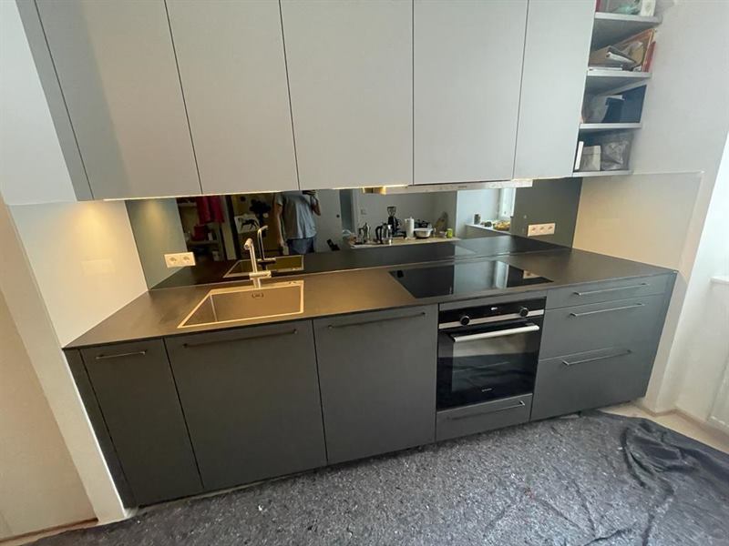 Küchenrückwand aus Glas, fugenlos zwischen Arbeitsplatte und Oberschrank montiert