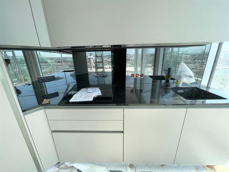 Küchenrückwand aus Glas, fugenlos zwischen Arbeitsplatte und Oberschrank montiert