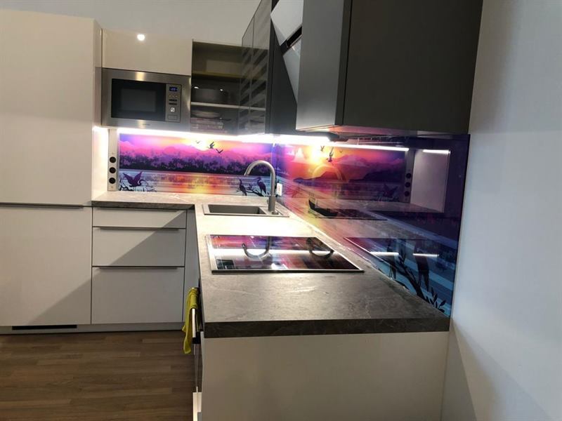 Küchenrückwand aus Glas, fugenlos zwischen Arbeitsplatte und Oberschrank montiert