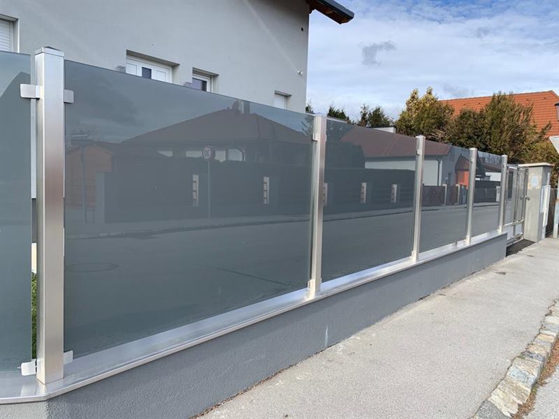 Sichtschutzwand aus mattiertem Glas mit Edelstahlrahmen im Außenbereich