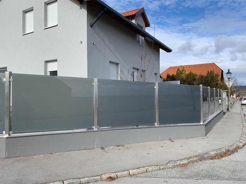 Sichtschutzwand aus mattiertem Glas mit Edelstahlrahmen im Außenbereich