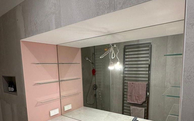 Wandspiegel nach Maß mit eingebauten Glasablagen in einem Badezimmer