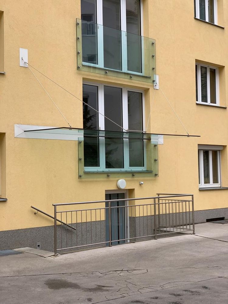 Glasvordach über dem Hauseingang eines Wohnhauses